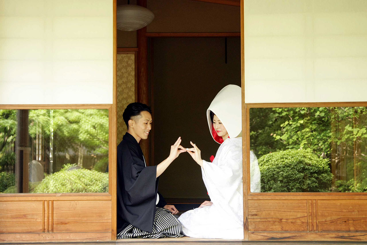 Y邸の茶室の中で見つめ合い指を合わせる新郎新婦